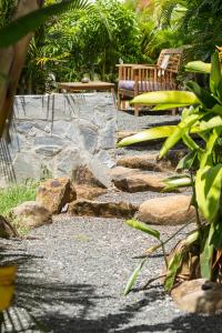 un giardino con panchina e sentiero in pietra di Iguana Ecolodge a Saint-François