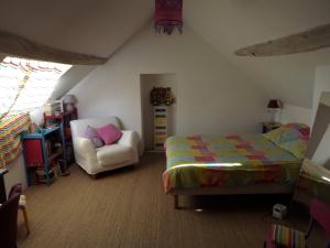 1 dormitorio con 1 cama y 1 silla en Les Anniquins, en Ivoy-le-Pré