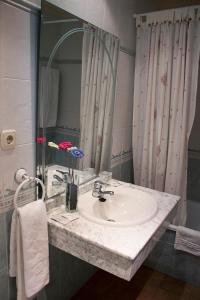 a bathroom with a sink and a vase of flowers at Albenzaire Hotel Asador in Fuensanta