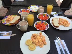 uma mesa preta com pratos de comida e bebidas em Arizona Ranch Hotel em Girardot