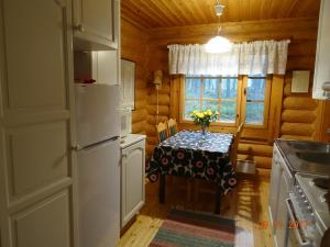 a kitchen with a table with flowers on it at Matila's Cottages in Sumiainen +5 photos