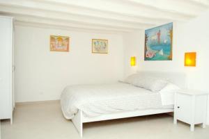 ローマにあるAppartamento Elsaの白いベッドルーム(ベッド1台付)が備わります。壁には絵画が飾られています。