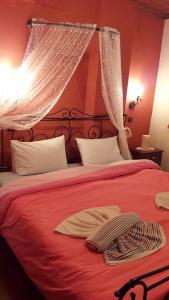 a bedroom with a red bed with a red blanket at Ippoliti in Palaioi Poroi