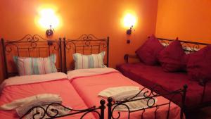 2 camas en un dormitorio con sábanas y almohadas rojas en Ippoliti, en Palaioi Poroi