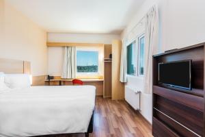 a bedroom with a bed and a television at ibis Puerto Montt in Puerto Montt