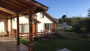 a house with a wooden porch and a house at La Barranca in Ushuaia