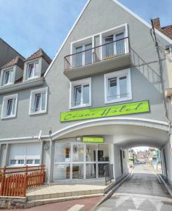 a gray building with a green sign on it at Brasserie Michel / Cesar Hotel in Le Portel