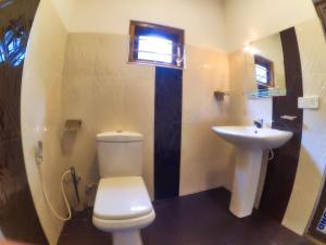 Un baño con un inodoro blanco y un lavabo. en Weligama Oriental Villa, en Weligama 29 fotos más
