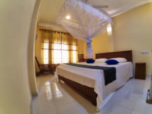 Un dormitorio con una cama grande con dosel. en Weligama Oriental Villa, en Weligama