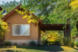 a house with a large window and a garage at El Refugio Casas de Campo in Villa General Belgrano