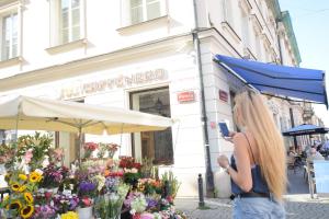 a woman taking a picture of a flower shop at Elegant Apartment Foksal in Warsaw