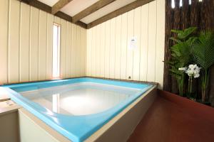 a bath room with a tub and a window at Kapiti Gateway Motel in Waikanae