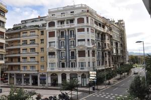 un gran edificio blanco en una calle de la ciudad en Pensión C7, en San Sebastián