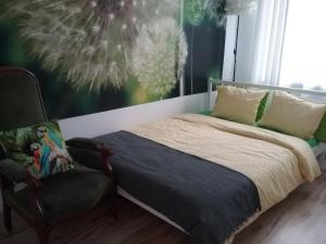 une chambre avec un lit et une chaise dans l'établissement Apartament Pod Wroną, à Toruń