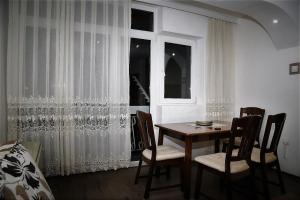 jadalnia ze stołem i krzesłami oraz oknem w obiekcie Comfort Inn Apartment 2 w mieście Novi Pazar