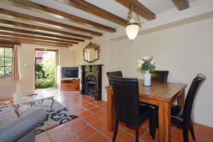 sala de estar con mesa y chimenea en Compass Cottage - Monaco Resort en Nelson