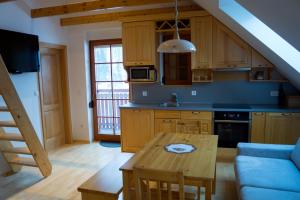 a kitchen with a wooden table and a blue couch at Apartmaji Lajf in Kranjska Gora