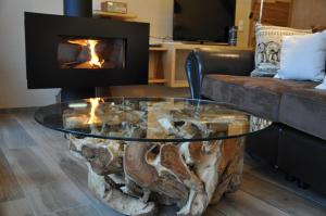 a coffee table made out of a tree stump with a fireplace at Morgenfurt - Appartements 3 Sterne und Erdhäuser 4 Sterne in Alleinlage in Weissensee