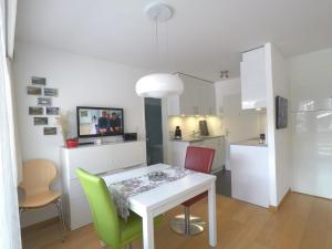 a kitchen and dining room with a white table and chairs at Haus Belmont in Zermatt