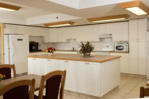 a large kitchen with white cabinets and a table at Western Budget Motel East Red Deer in Red Deer