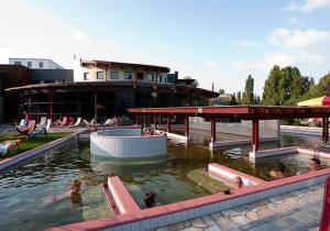 a group of people swimming in a swimming pool at Hostel Maros in Győr