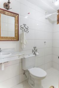 ein Badezimmer mit einem WC, einem Waschbecken und einem Spiegel in der Unterkunft Pouso copo de leite in Tiradentes