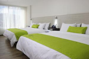 
a hotel room with two beds and two lamps at Arame Hotel in Envigado
