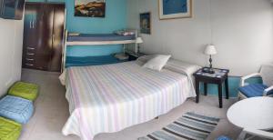Suites Atlantis في بونتا دل إستي: غرفة نوم مع سرير وسريرين بطابقين