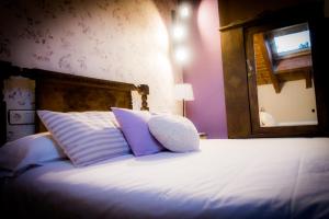 Curiel de DueroにあるLa Casa del Medioの紫と白の枕と鏡付きのベッド