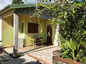 a small house with a table and chairs in front of it at Les Nids de Belle Eau 1 gîte sur 2 avec jacuzzi in Capesterre-Belle-Eau