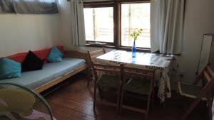 Habitación con sofá, mesa y ventana en Cabañas Pietragalla, en Punta del Diablo