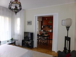 a bedroom with a bed and a living room with a table at Apartment Deligradska in Belgrade