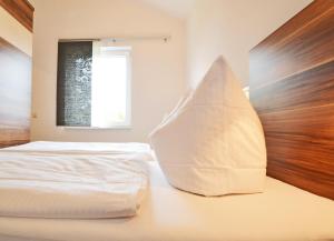 ツィノヴィッツにあるHaus Ostseekristall Wohnung Smaragdのベッドルーム(白いベッド1台、木製ヘッドボード付)