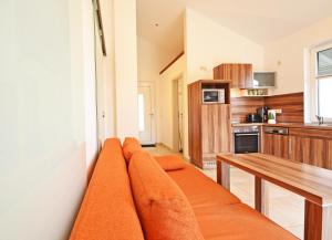 sala de estar con sofá naranja en la cocina en Haus Ostseekristall Wohnung Smaragd, en Zinnowitz