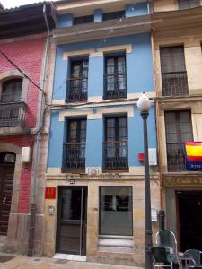 a blue building with windows and a street light at Apartamentos Entrepalacios in Avilés