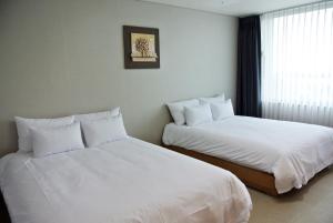 Postel nebo postele na pokoji v ubytování Jeju Noblesse Hotel