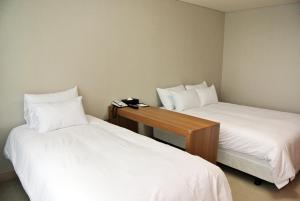 Postel nebo postele na pokoji v ubytování Jeju Noblesse Hotel