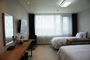 Postel nebo postele na pokoji v ubytování Jeju Noblesse Hotel