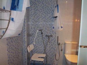 y baño con ducha, aseo y sombrilla. en Apartamentos Entrepalacios, en Avilés