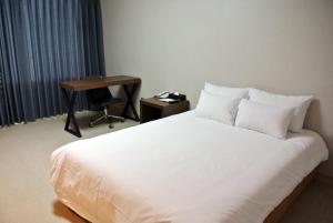 Postel nebo postele na pokoji v ubytování Jeju Noblesse Hotel