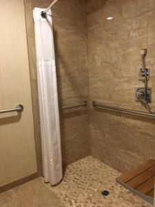 a shower with a white shower curtain in a bathroom at Best Western Plus Carriage Inn in Sherman Oaks