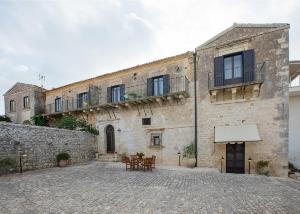 an old stone building with tables and chairs in front of it at Agriturismo Villa Flavia in Casa Serrafiori