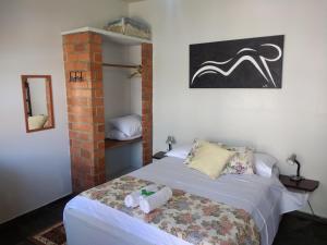1 dormitorio con 1 cama con toallas en Residência Toca do Cação, en Búzios