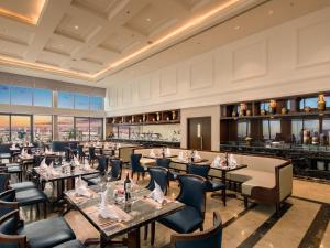 Un restaurante con mesas y sillas y un bar. en Altara Suites Da Nang by AHG, en Da Nang