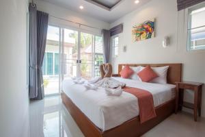 a bedroom with a large bed with a large window at Thuan Resort in Rawai Beach