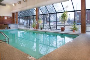 a large swimming pool in a building with glass windows at Crossroads Hotel and Huron Event Center in Huron