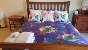 1 cama con edredón y almohadas de color púrpura en Beezneez B&B, en Orford