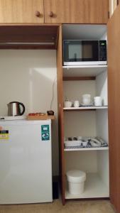 a small kitchen with a microwave and a refrigerator at Beezneez B&B in Orford