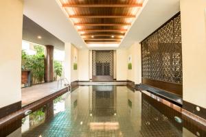 a swimming pool in a house with a ceiling at De Chai Colonial Hotel & Spa - SHA Plus in Chiang Mai