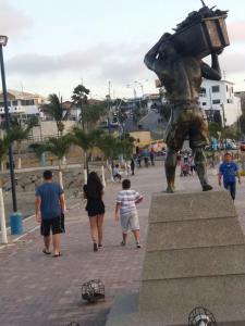 un grupo de personas caminando alrededor de una estatua en Hostal Haziel, en Salinas